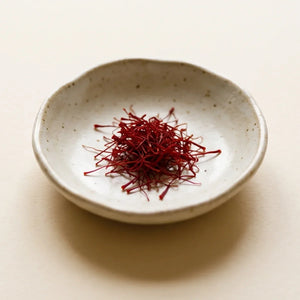 Saffron threads in a small ceramic dish, a natural extract studied for reducing anxiety and low mood