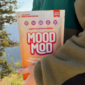 Person on a sunny hillside trail holding a bag of Mood Mod, a parent's guide to helping a stressed teenager | Mood Mod