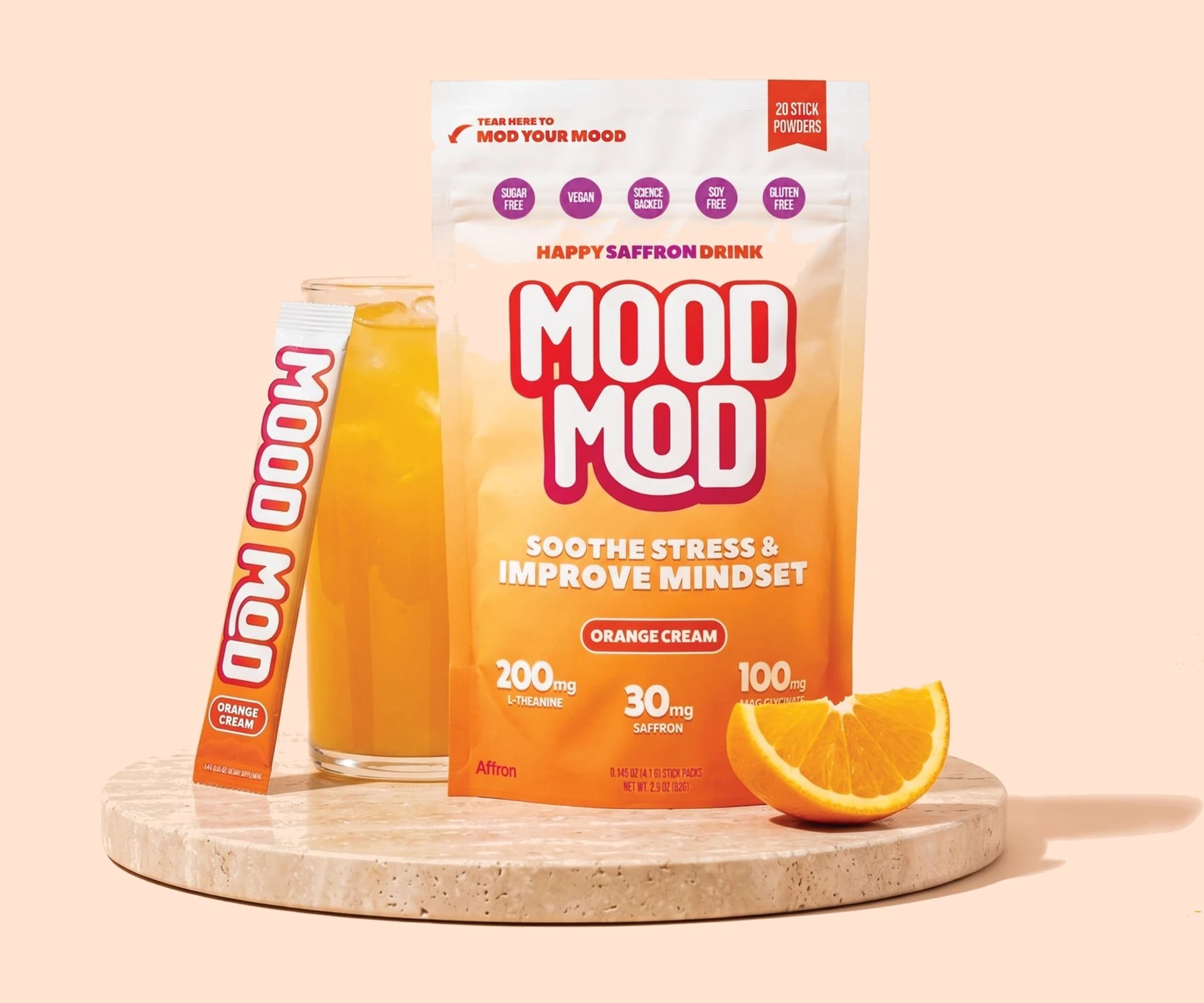 Mood Mod Orange Cream pouch with stick pack and glass of the drink on a travertine tray