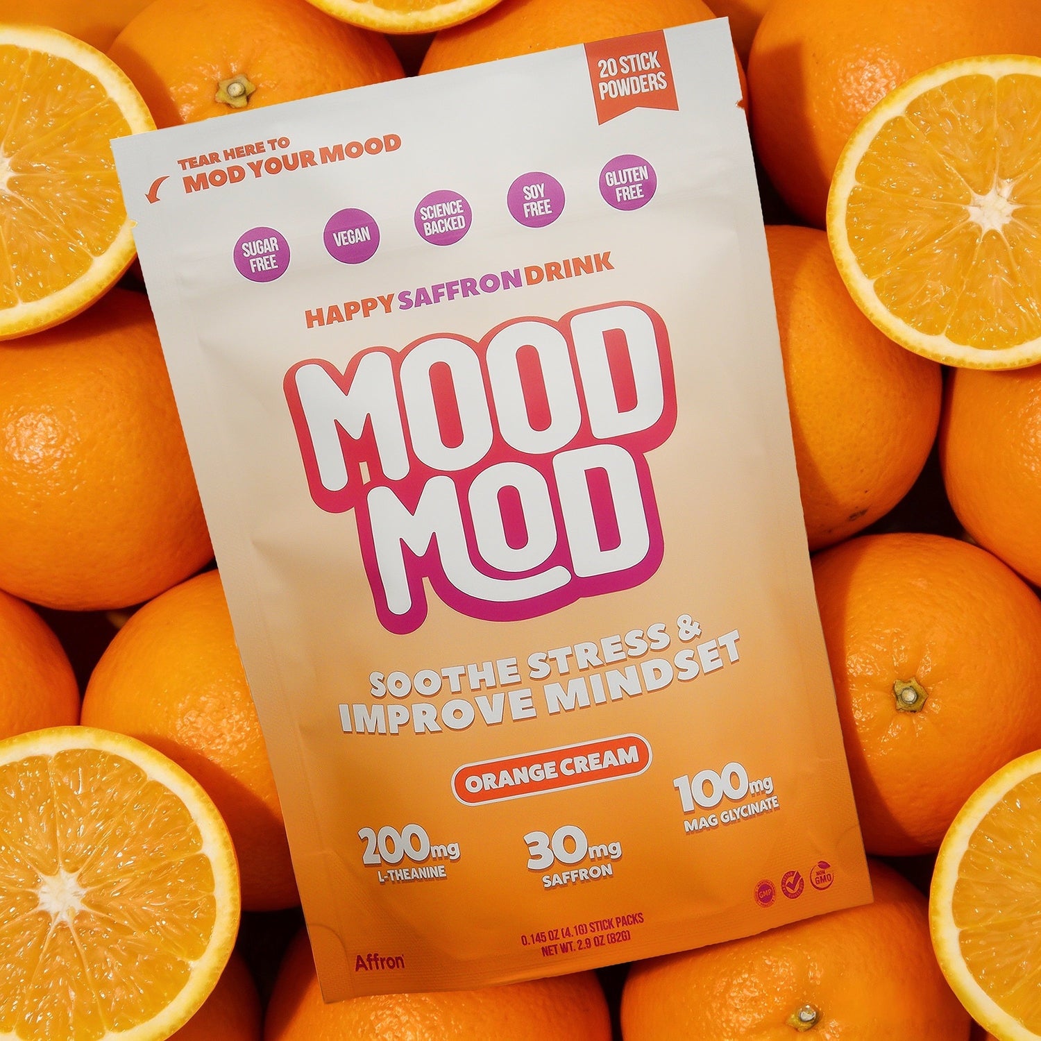 Pouch of Mood Mod Orange Cream "Happy Saffron Drink" surrounded by fresh orange slices.