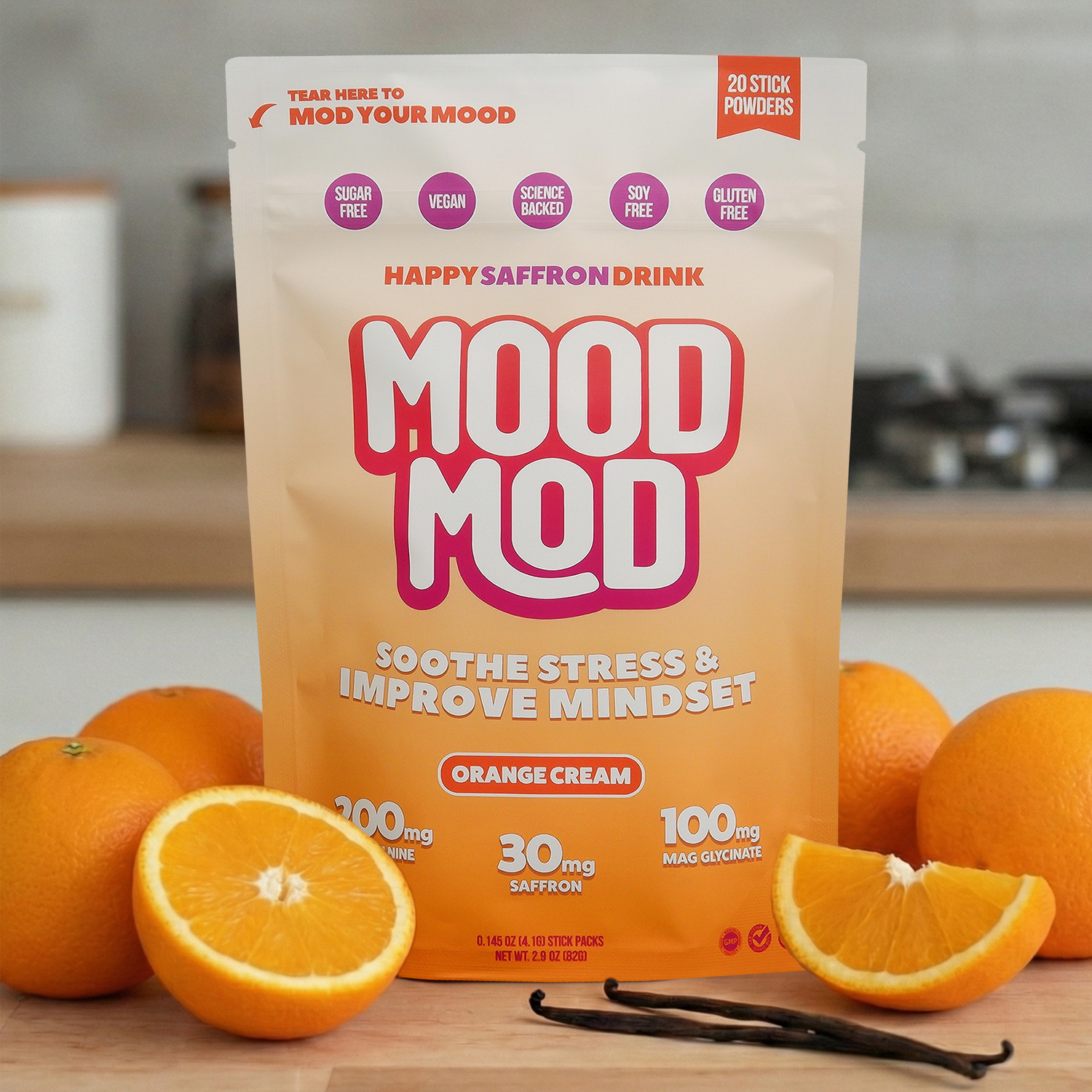 Mood Mod Orange Cream saffron drink mix pouch on a kitchen countertop surrounded by fresh oranges and vanilla beans