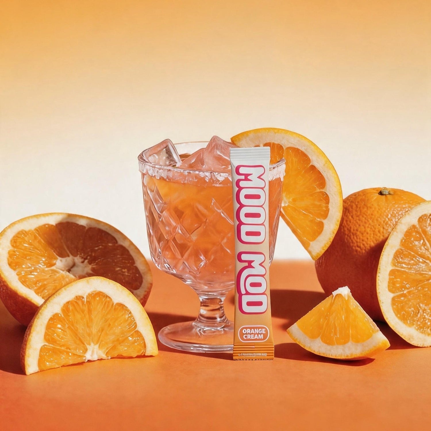 Mood Mod Orange Cream stick pack with iced saffron drink in a sugar-rimmed glass surrounded by fresh oranges, daily mood support drink mix