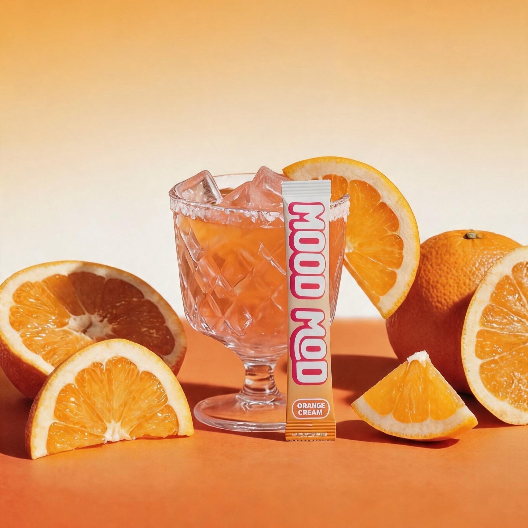 Mood Mod Orange Cream stick pack with iced saffron drink in a sugar-rimmed glass surrounded by fresh oranges, daily mood support drink mix