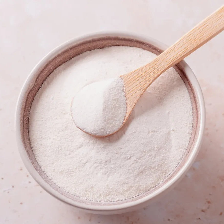 Magnesium glycinate powder in a ceramic bowl with a wooden scoop