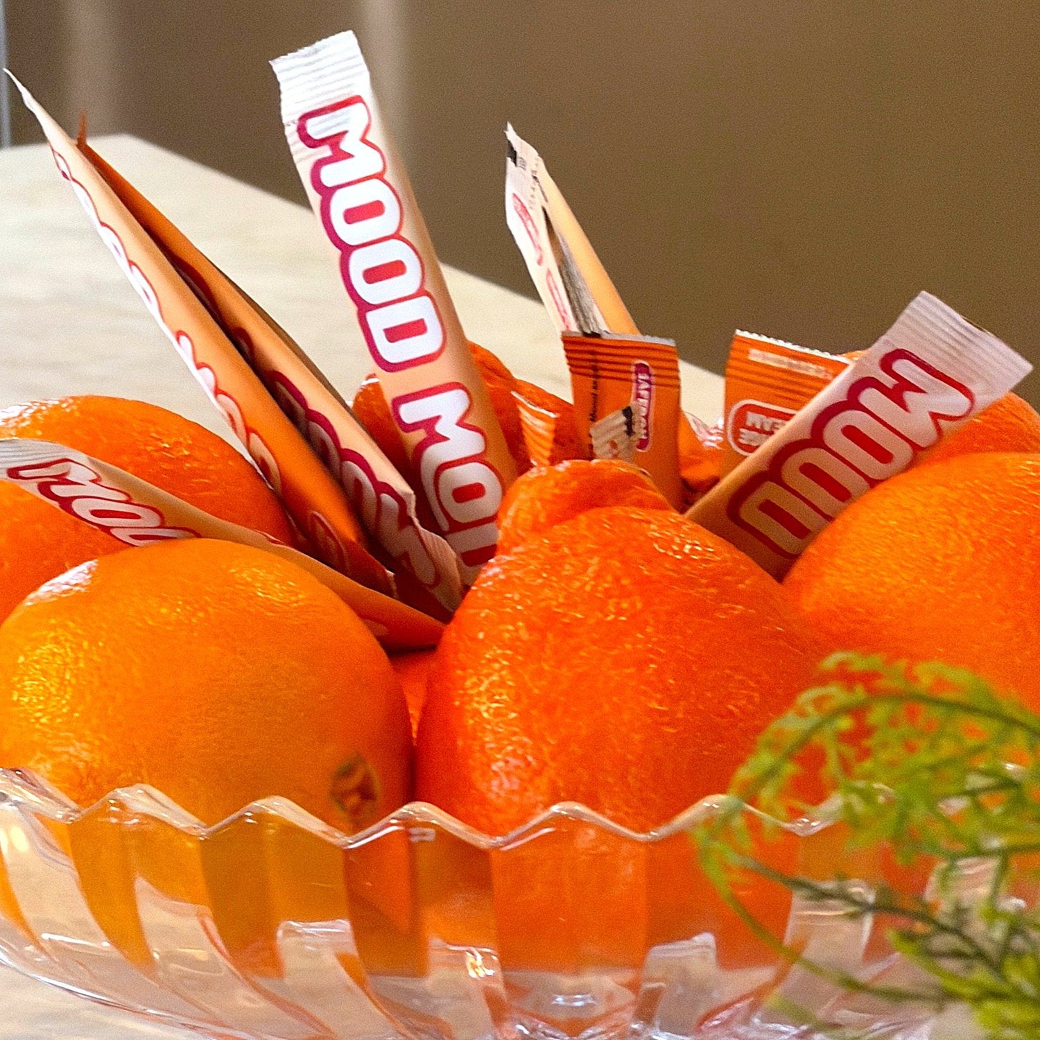 Mood Mod and Nello saffron stick packs standing in a bowl of fresh oranges for a mood supplement comparison