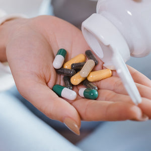 Hand holding assorted saffron supplement capsules poured from a bottle, comparing the best saffron supplements of 2026 by Affron extract, dose, and form | Mood Mod