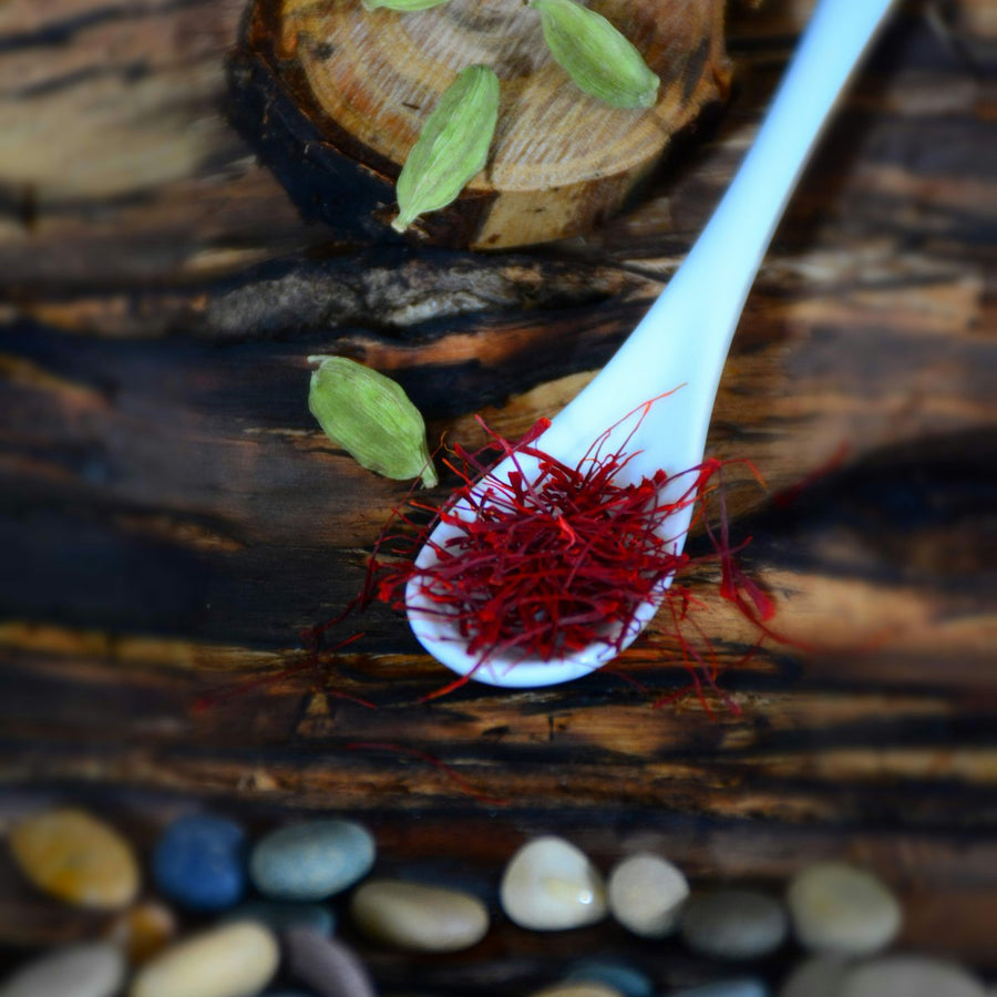 Red saffron threads on a white spoon, illustrating saffron side effects and safety: is saffron safe to take daily at the studied 28 to 30mg dose