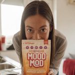 Marina S., verified Mood Mod customer, holding a Mood Mod pouch